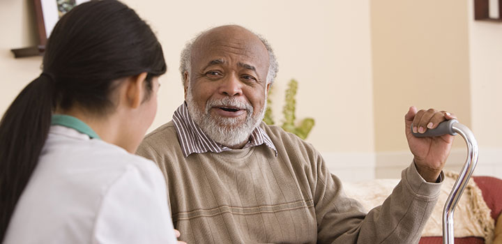 An elderly man speaks with a younger woman