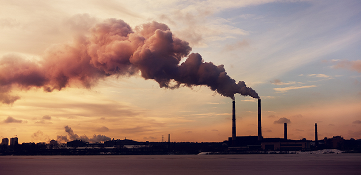 A power plant with columns of emissions rising up.