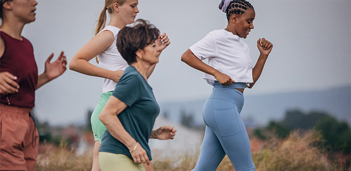Four women running in activewear.