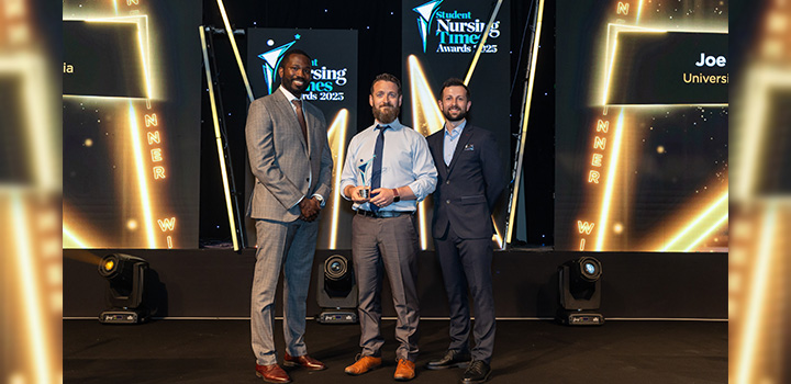 Three men stood on a stage