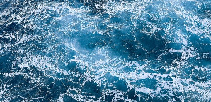 Swirling pattern of ocean water, turbulent sea.