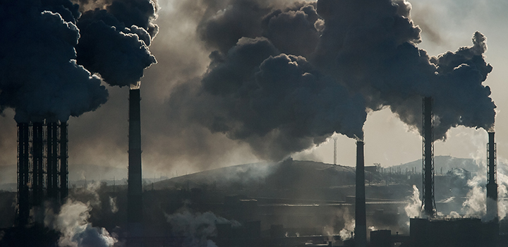 Grey sky with several chimneys emitting smoke