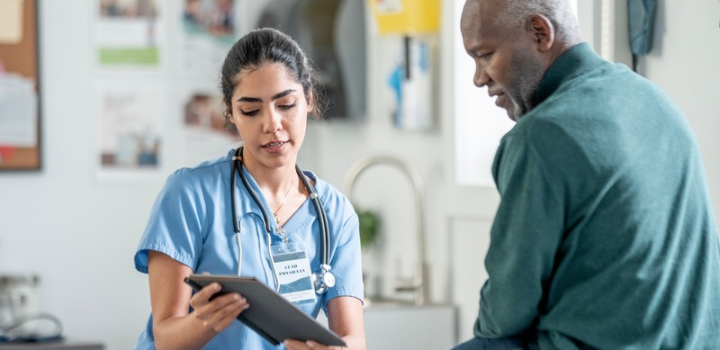 A healthcare professional showing a tablet to a patient while in discussion