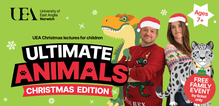 A green UEA banner featuring Prof Ben Garrod and Dr Jess French smiling back to back with red Santa hats on