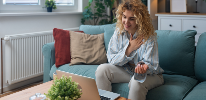 A woman smiling down at her laptop, looking relieved