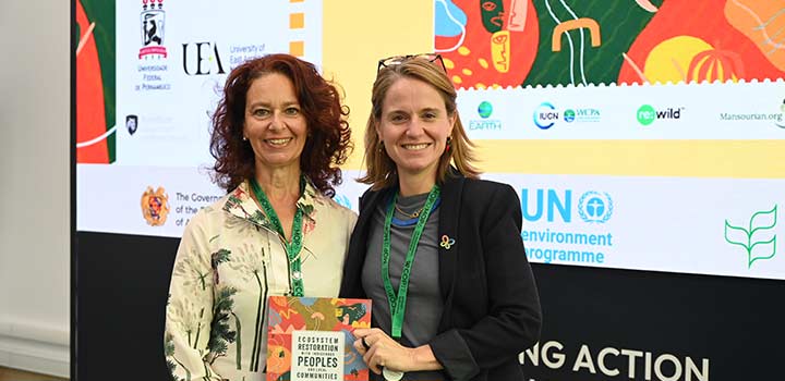 A photo of Stephanie Mansourian celebrating the launch at COP17 of the Ecosystem Restoration with Indigenous Peoples and Local Communities: A Practical Guide