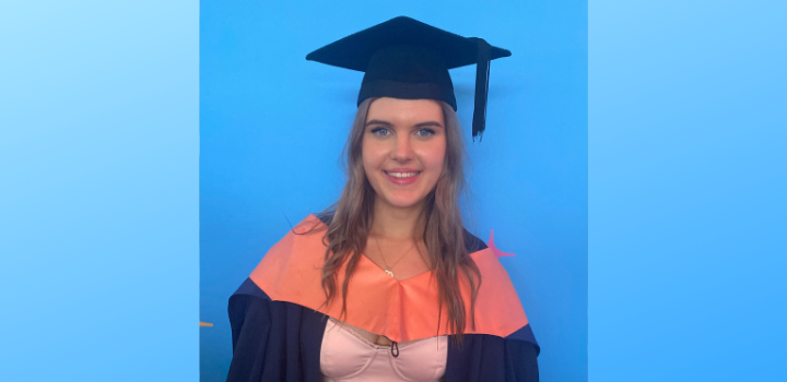 Abigail Hennis smiling in her graduation gown and cap