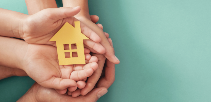 Three pairs of hands outstretched and holding a yellow outline of a house, all in front of a blue-green background