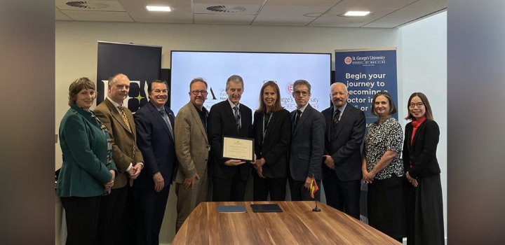A group of individuals standing in front of a whiteboard, holding up a certificate