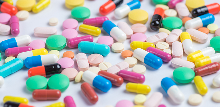 An assortment of pills scattered on a tabletop.