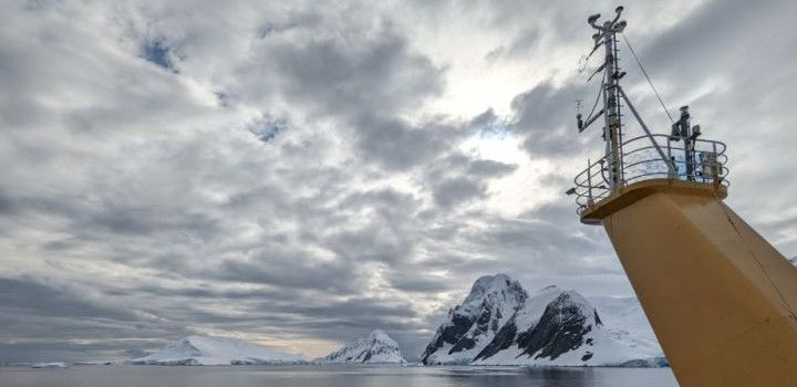 Air-sea flux measuring system on the mast of research ship the RRS Sir David Attenborough , with view of Antarctica in the background