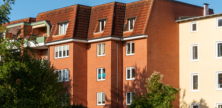 A block of flats behind some trees.