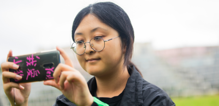 International student Huizhi Yang from China takes a picture in front of the Ziggurats