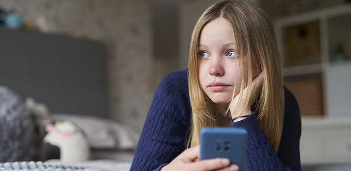 A teenage girl with her mobile phone in her hand