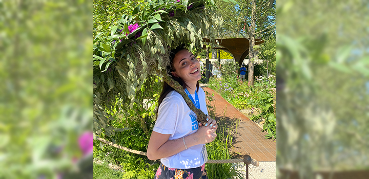 Hana Bel Haj smiling in front of a green background of trees