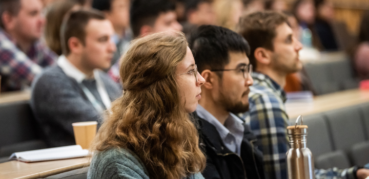 A group of people sat in a lecture theatre facing the front