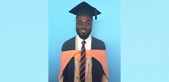 Shariff Hakeem smiling at the camera in a graduation cap and gown