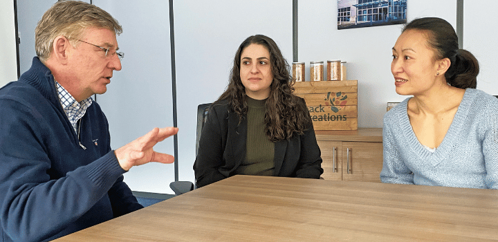 Colleagues from Snack Creations and UEA having a meeting around a table