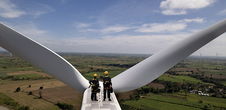 A wind turbine with two engineers at the top.