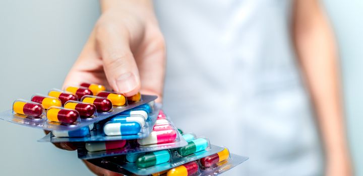 Outstretched hand holding several packets of tablets