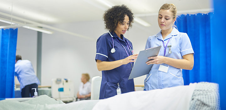 Two triage nurses looking at a clipboard.