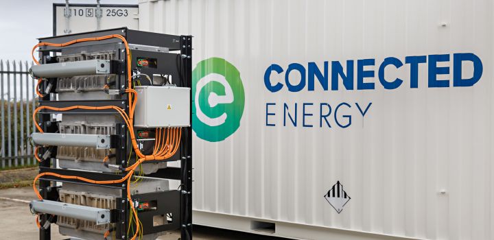 Recycled electric car batteries stand in front of a shipping container bearing the logo of the company Connected Energy