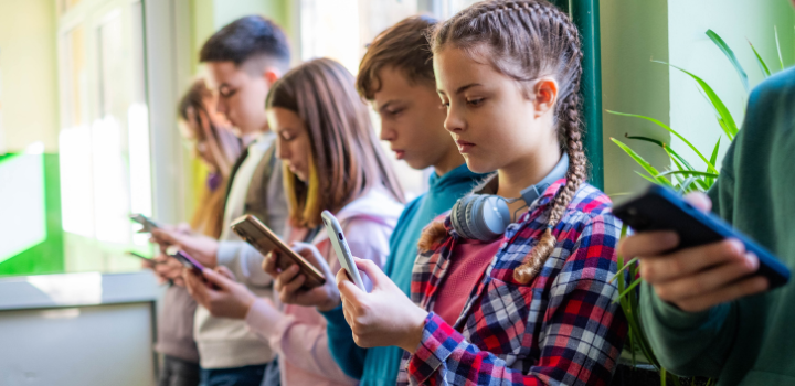 A line of children all staring at phone screens
