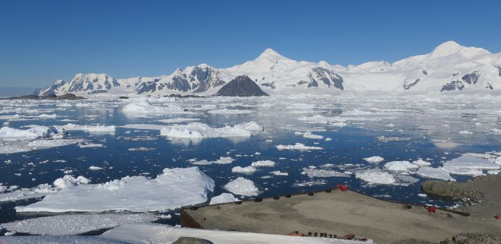 Wharf of Rothera Research Station, Antarctica, looking over part of Ryder Bay, with sea ice on the sea and snow-covered mountains in the distance