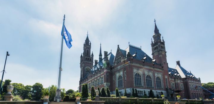 Outside of the building housing the International Court of Justice with a flag pole in the foreground