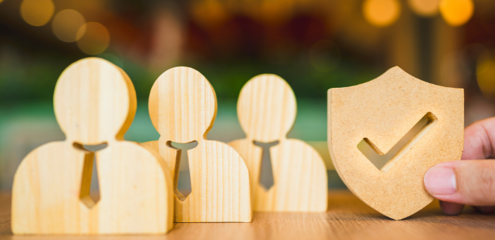A red cartoon house being picked up by a hand with surrounding buildings in the back,  there is a background of a blue sky with some white clouds