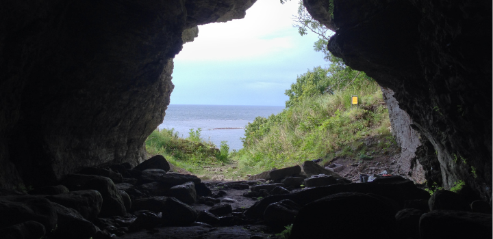 Photo taken inside a cave, looking out at an ocean