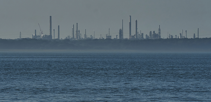 An ocean with an industrial skyline.