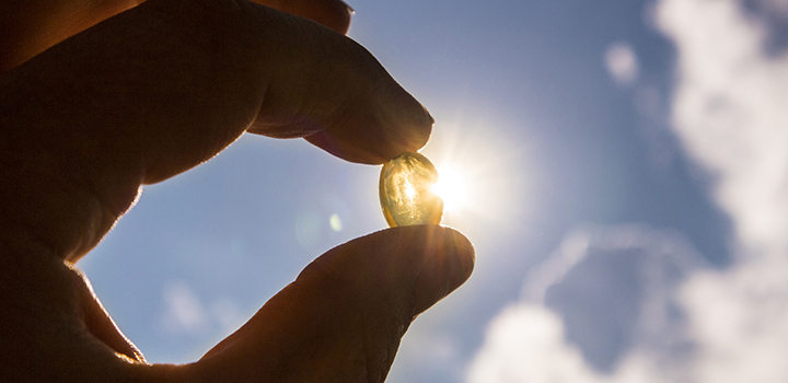 A Vitamin D tablet being held up to the sun.