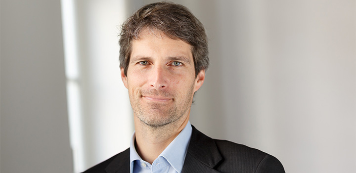 Prof Peltzer smiling; he is wearing a shirt and blazer.
