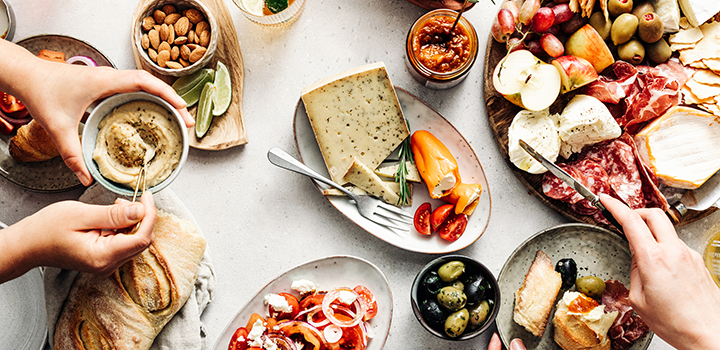 Two people eating a range of Mediterranean dishes.