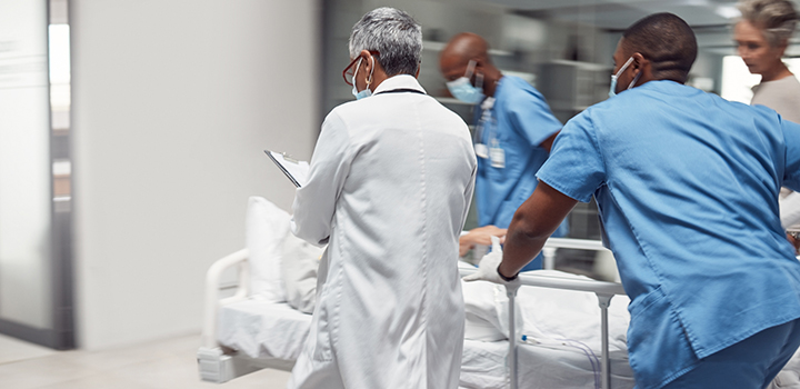 A medical team attend to a patient in an emergency care department.