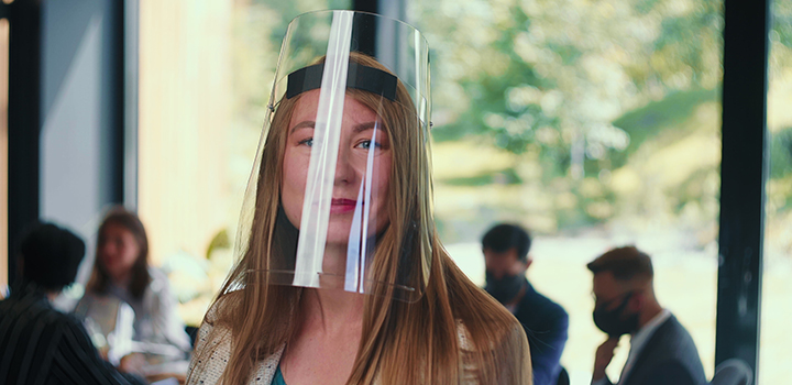 A woman wearing a plastic face shield.