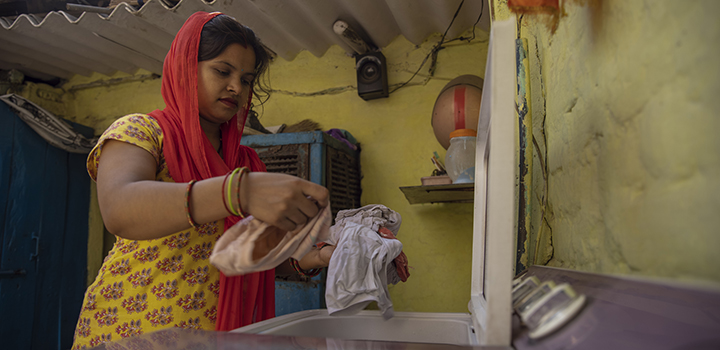 An Indian woman uses a washing machine.