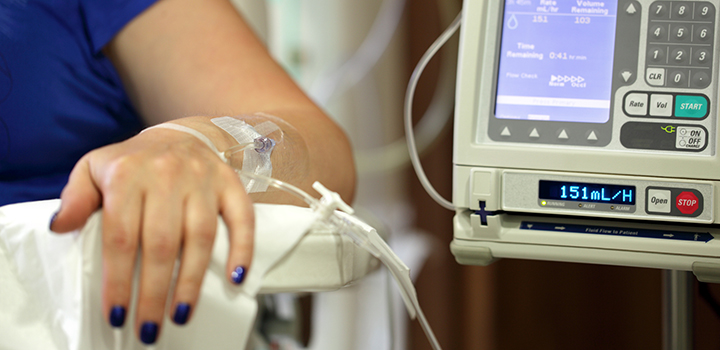A woman's arm attached to an IV drip.