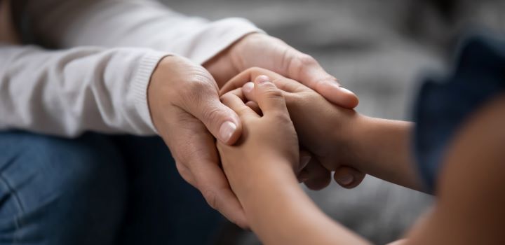 Adult holding a child's hands