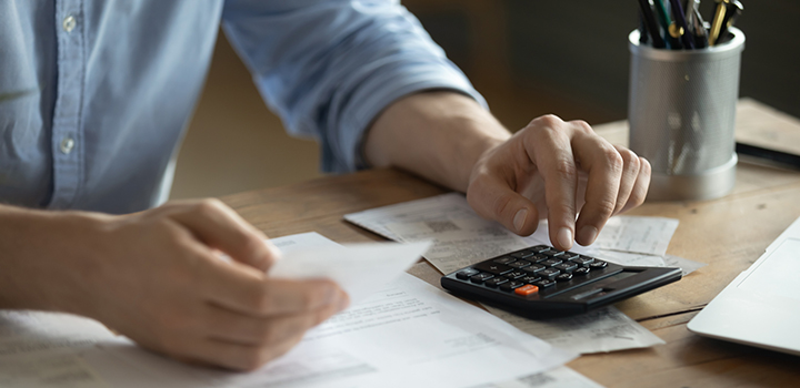 Image of someone using a calculator to calculate bills