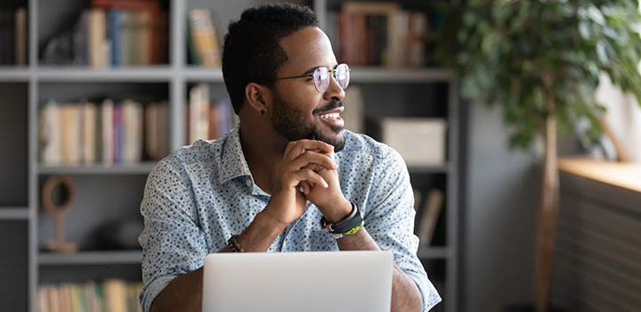 A man at work smiles looking out of a window.