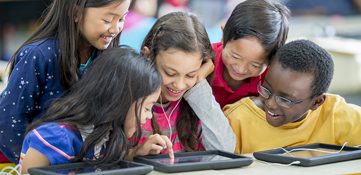 A group of children playing on tablets.