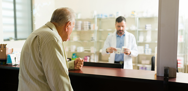 An elderly man waiting at a care home pharmacy