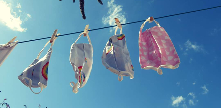 Face masks of various designs drying on a washing line.