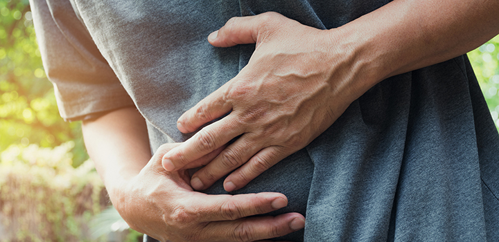 A man clutches his stomach.