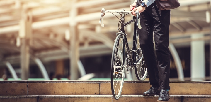 Smart businessman holding bicycle