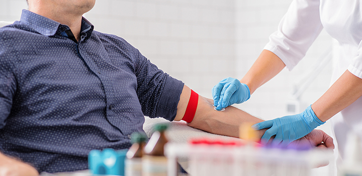 A man having a blood test administered by a healthcare professional.